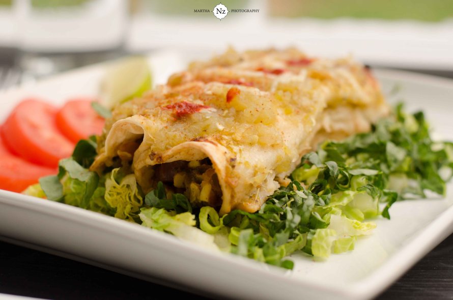Vegetarian enchiladas made with homemade tomatillo sauce and served on a bed of lettuce and tomatoes.
